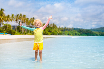 Child on tropical beach. Sea vacation with kids.