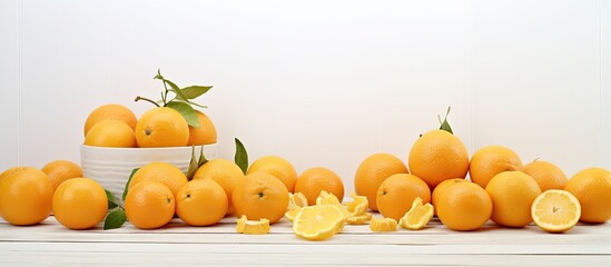 A variety of tangerines including peeled ones and slices are arranged on a white wooden table creating a copy space image