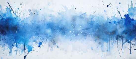 A copy space image of a grunge distressed splatter background with blue ink splashes spray paint drops and noise stains on a white paper