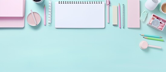 Top view copy space image of pastel colored workspace adorned with office supplies in a flat lay style