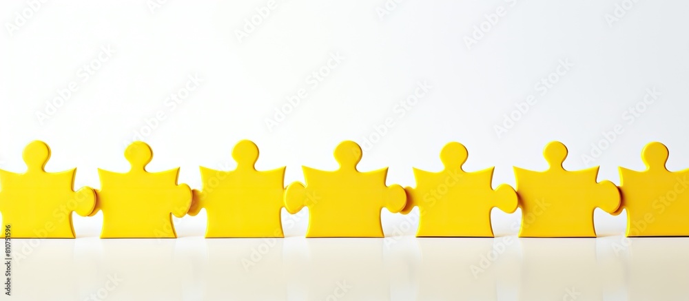 Poster A lineup of yellow puzzle pieces on a textured white background emphasizing the concept of teamwork Copy space image available