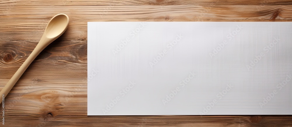 Aufkleber Top view of a wooden table with a close up shot of a cooking wooden spatula and lined paper creating a copy space image