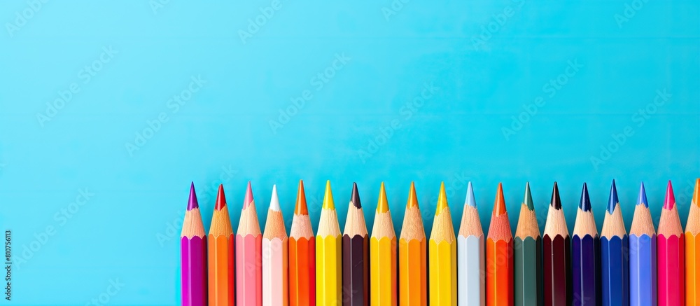 Poster A vibrant arrangement of colored pencils against a pastel backdrop creating a visually captivating copy space image