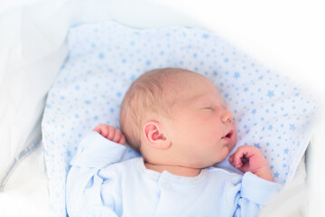 Sleeping newborn baby boy in a stroller