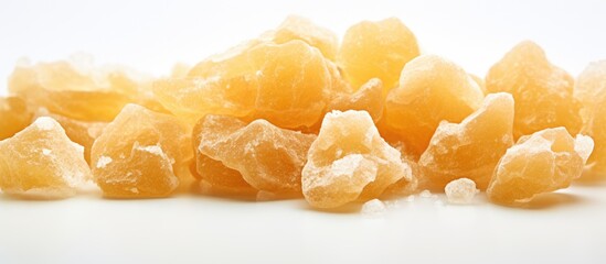 A macro photo of crystallized ginger with a shallow depth of field on a white background providing copy space