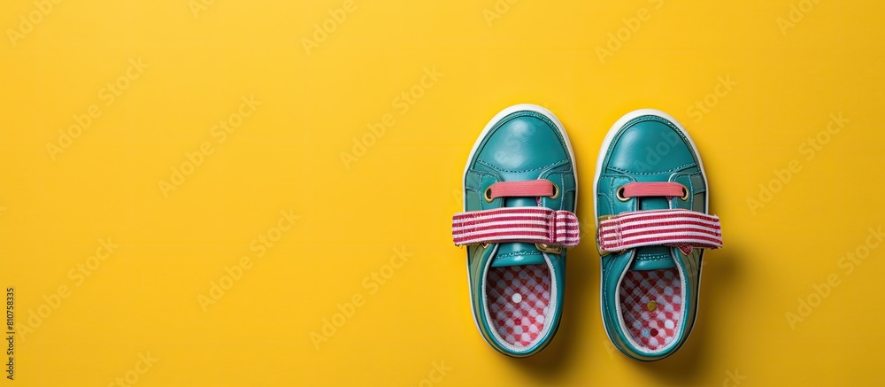 Poster A top view photo of a pair of child s shoes placed on a colorful background ready for use as a flat lay copy space image