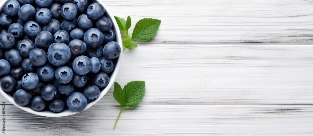 Aufkleber a summery image of ripe blueberries arranged in a blue bowl on a white wooden surface seen from abov