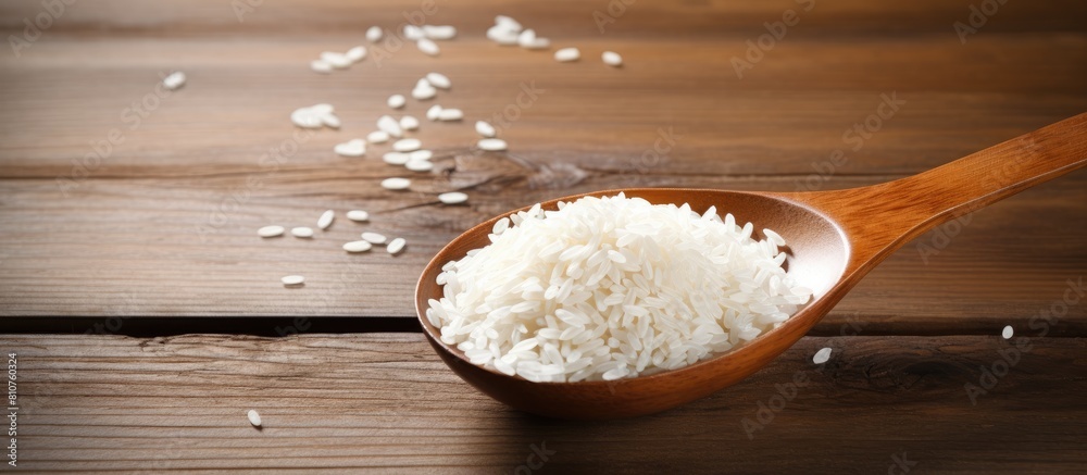 Poster a copy space image of rice with a spoon placed on a wooden background
