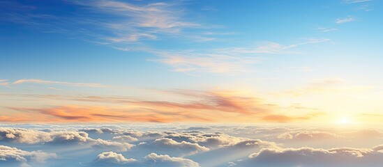 Fototapeta premium In the morning there is a breathtaking natural background featuring a picturesque sunrise a clear blue sky and a cluster of fluffy white clouds Perfect for copy space image