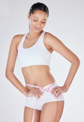 Fototapeta premium Woman, measuring tape and stomach in studio for health, tracking progress and white background. Female person, weight loss and results of liposuction or tummy tuck, cosmetic change and transformation