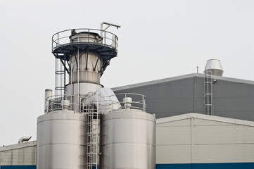 elements of a dairy factory against a background of gray sky