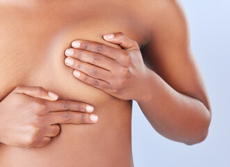 Woman, hands and exam breast in studio, health and check for cancer in assessment on blue...