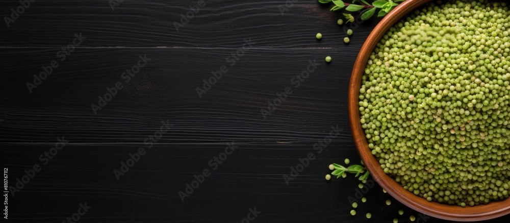 Poster top view of raw green buckwheat on a black wooden background with plenty of copy space for an image