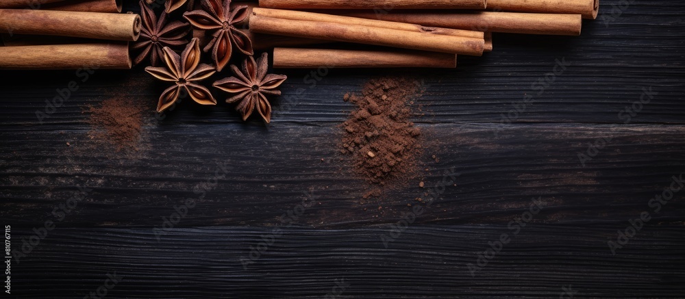 Poster Top view of cinnamon sticks on a dark wooden background creating a captivating copy space image This condiment is perfect for making mulled wine
