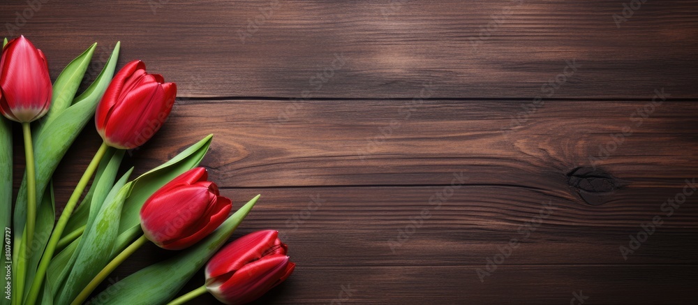 Poster a top down view of red tulips displayed on a rustic wooden table with ample empty space for other el