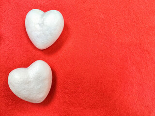 Obraz premium White foam hearts on a red background. The texture. valentine's day. Two White Foam Hearts on a Textured Red Background for Valentines Day