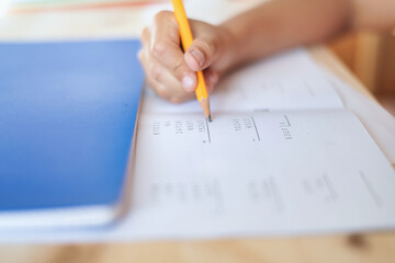 Close-Up Of A 9 Year Old Boy Using A Pencil Doing Math Exercises. Childhood Education.