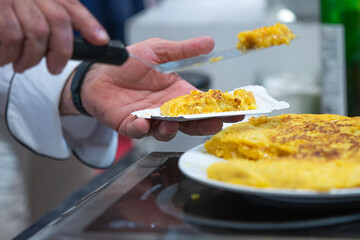 Spanish omelette. Cook cutting a Spanish omelette. Potato omelette