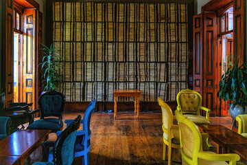 Stacks of old journals, newspapers on wall.