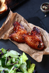 Grilled chicken wings. The grilled wings are laid out on craft paper. An appetizer for beer.
