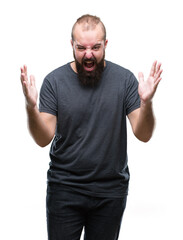 Naklejka premium Young caucasian hipster man over isolated background crazy and mad shouting and yelling with aggressive expression and arms raised. Frustration concept.