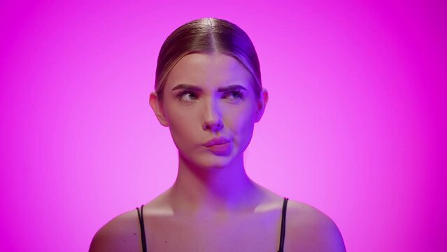 Cute woman makes silly faces with mouth and rolling eyes, thinking about