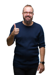 Young caucasian hipster man wearing sunglasses over isolated background doing happy thumbs up gesture with hand. Approving expression looking at the camera with showing success.