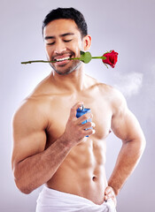 Flower, cologne and man with spray from cosmetics on studio background with rose perfume. Skincare,...