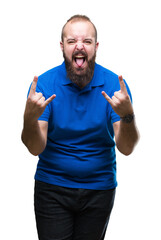 Fototapeta premium Young caucasian hipster man wearing blue shirt over isolated background shouting with crazy expression doing rock symbol with hands up. Music star. Heavy concept.