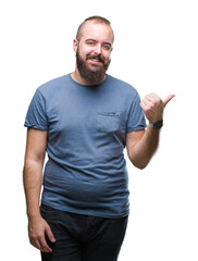 Young caucasian hipster man over isolated background smiling with happy face looking and pointing to the side with thumb up.