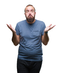 Young caucasian hipster man over isolated background clueless and confused expression with arms and...