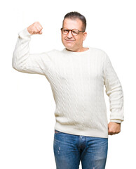 Middle age arab man wearing glasses over isolated background Strong person showing arm muscle, confident and proud of power