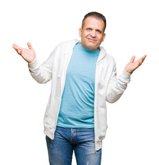 Naklejka premium Middle age arab man wearing sweatshirt over isolated background clueless and confused expression with arms and hands raised. Doubt concept.