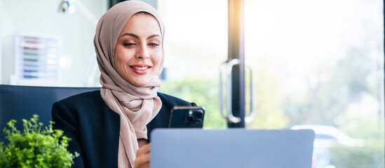 Dynamic Muslim businesswoman, adorned in a hijab, orchestrates success through her mobile device at her desk. market order, bootstrapping, USP, fiduciary responsibility, business world with finesse.