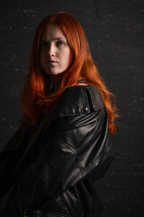 Naklejka premium Portrait of a young beautiful red-haired girl in a low key.