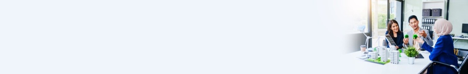 Trio of businesspeople, including a middle-aged Asian man and woman, strategize at their desk, prioritizing sustainability renewable energy adoption, waste reduction, and eco-friendly practices.