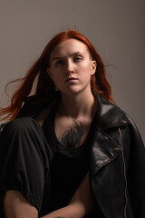 Portrait of a young beautiful red-haired girl in a low key.