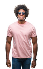 Afro american man wearing sunglasses over isolated background with serious expression on face. Simple and natural looking at the camera.