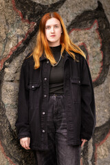 Naklejka premium Portrait of a young beautiful red-haired girl in a low key.