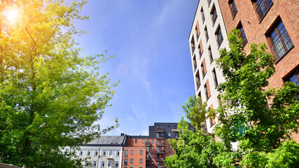 Modern residential building with new apartments in a green residential area. Eco architecture. Green tree and new apartment building. The harmony of nature and modernity.