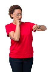 Beautiful young african american woman wearing glasses over isolated background Looking at the watch time worried, afraid of getting late