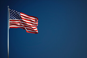 Deep blue sky frames a fluttering Memorial Day flag, celebrating patriotism.