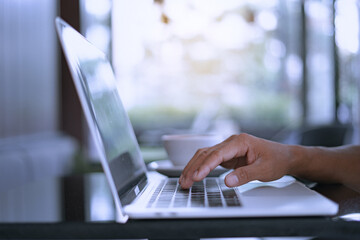 Young businessman's hands typing on laptop