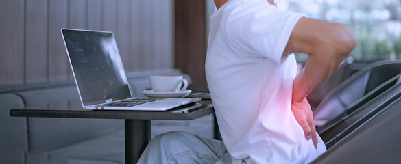 Close-up of a man with severe back pain after sitting for a long time.