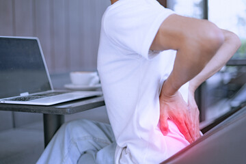 Close-up of a man with severe back pain after sitting for a long time.