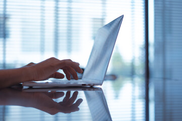 Young businessman's hands typing on laptop