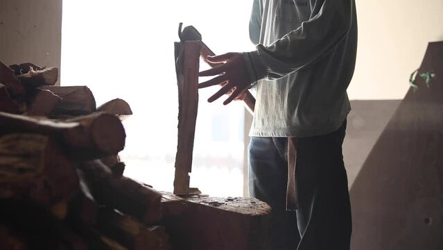 A man is chopping firewood with an axe