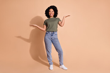 Photo portrait of pretty young woman hands compare empty space dressed trendy khaki outfit isolated on beige color background