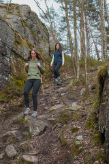 Obraz premium Two young girls going down a hill during a hike in the forest