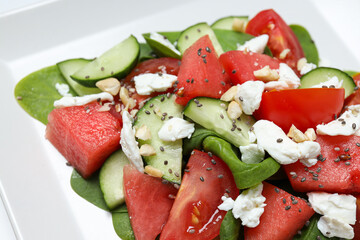 Watermelon salad in a square bowl, close-up view